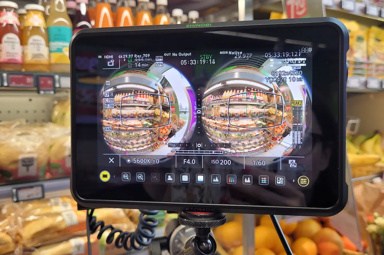 A 360° camera monitor showing a fisheye view of a Żabka store aisle
